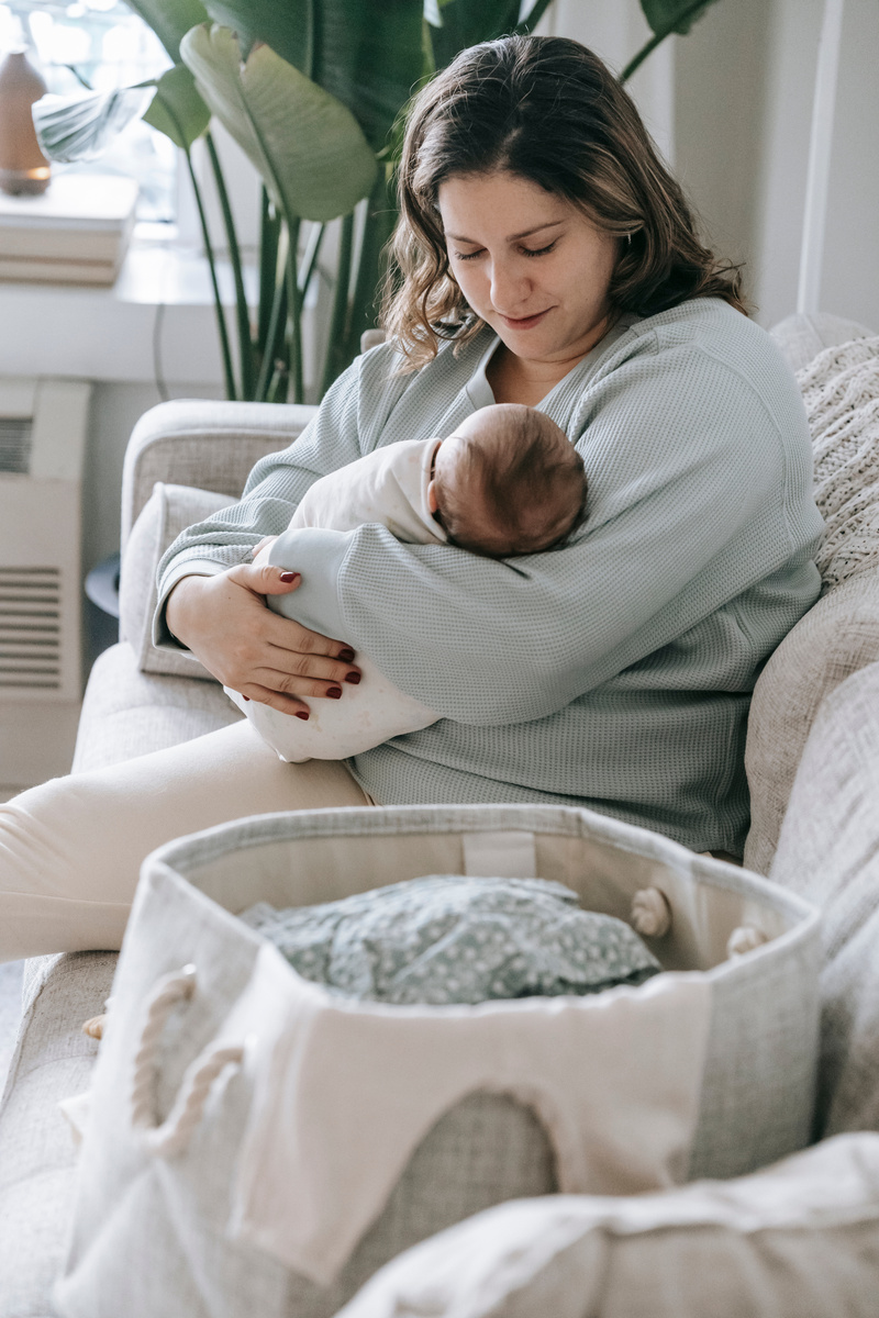 Mother with newborn baby on couch